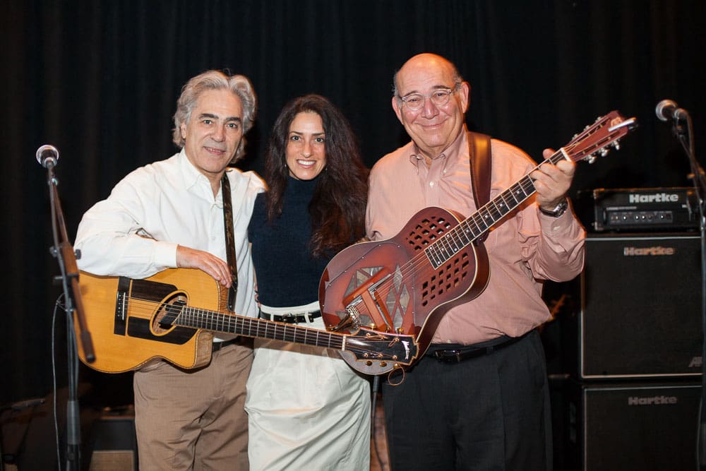 Woody Mann (left) with his wife Valerie Lettieri Mann and CPF Board Vice Chair, David Pinter. Mann and Pinter are holding guitars, and everyone is smiling for a group photo.