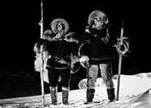 A still from the short film, "Nalujuk Night." It a black and white still shot of two masked figures standing side by side.