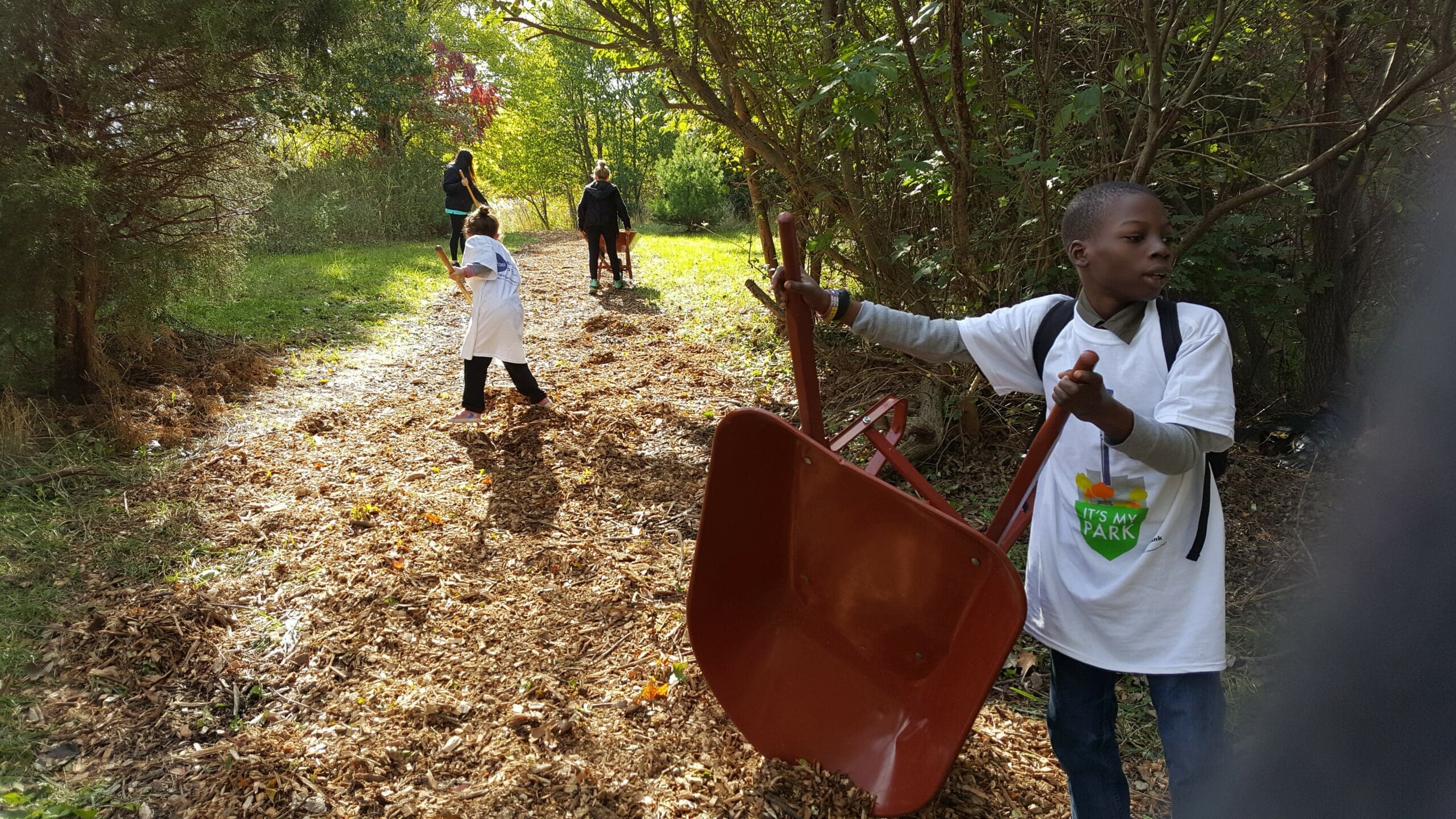 Young kids volunteering at an It's My Park project, beautifying a New York City park.