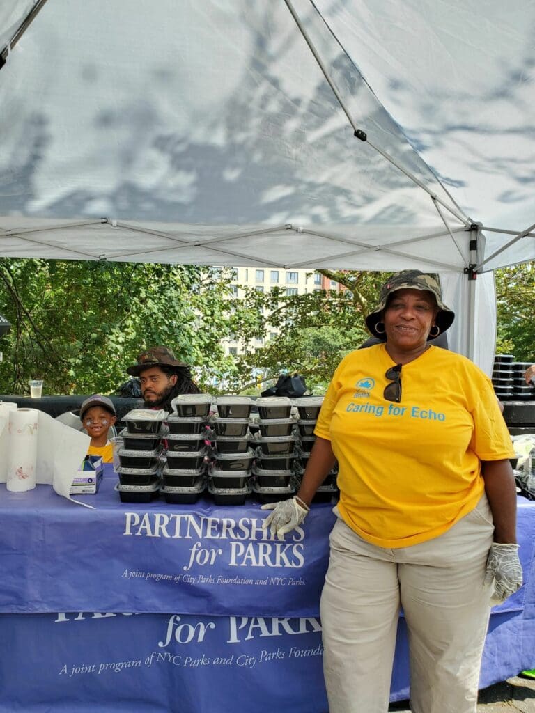 a woman standing in front of a table with food containers