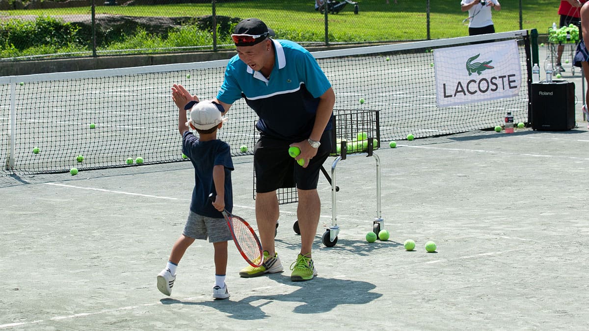 a man and child on a tennis court