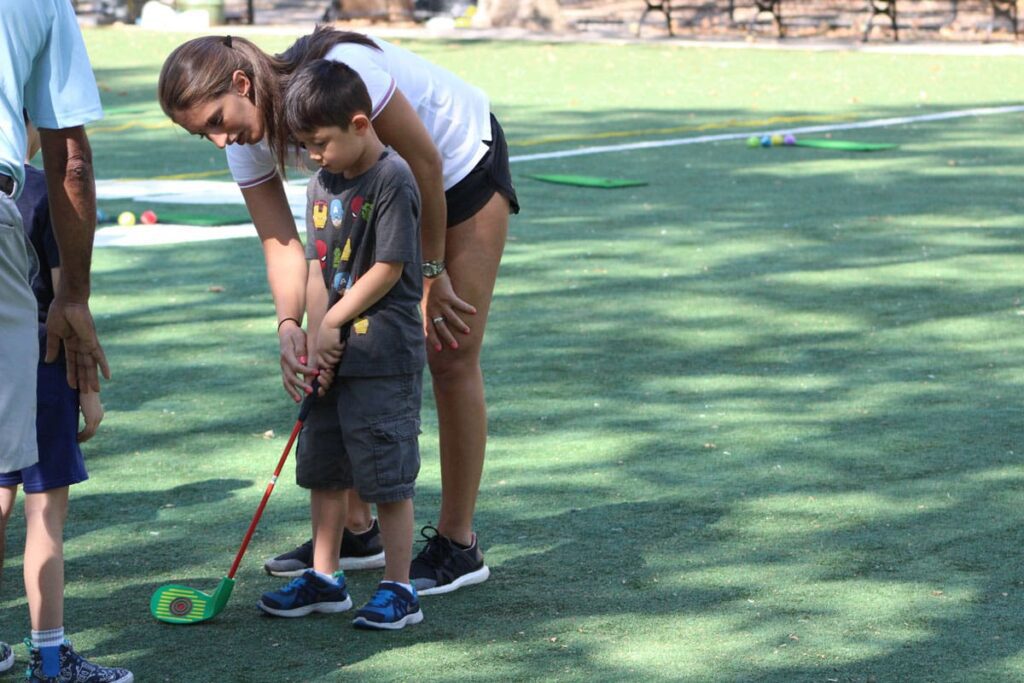 a woman and a boy playing golf