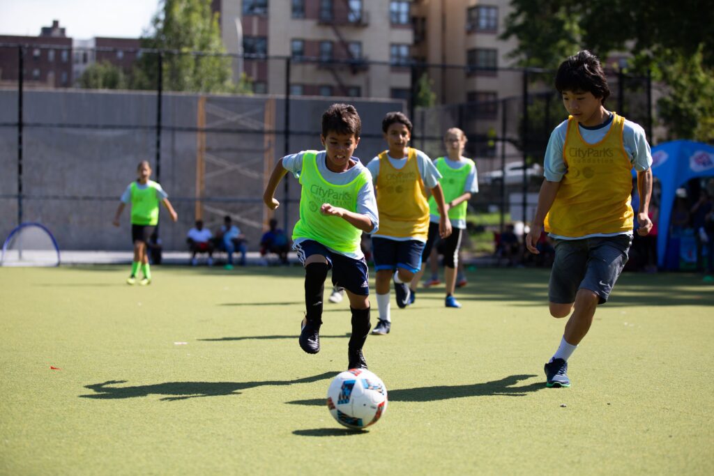 youth playing soccer outdoors