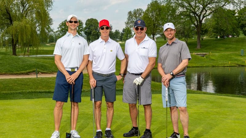 A winning foursome shot - four smiling white men in golf attire - at the Waterman Golf Classic in 2019 presented by City Parks Foundation