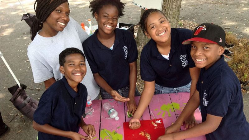 A group of smiling kids make salsa at the Learning Gardens