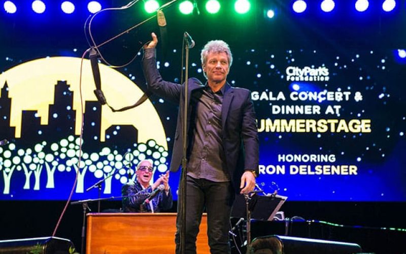 Thumbnail image: musician Jon Bon Jovi stands holding their guitar in the air after performing at the CPF gala