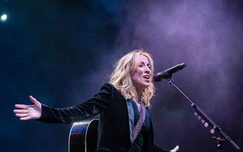 A thumbnail photo of artist Sheryl Crow performing on-stage.
