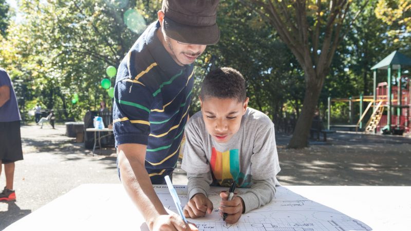 a man and boy writing on a paper